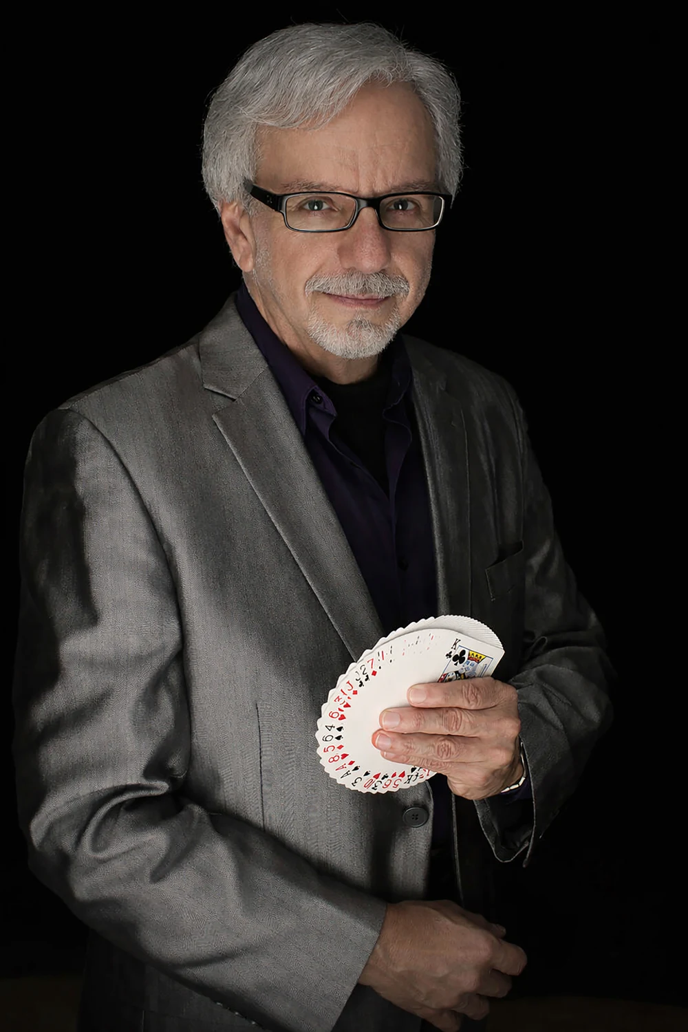 Jim Sisti holding a fan of playing cards